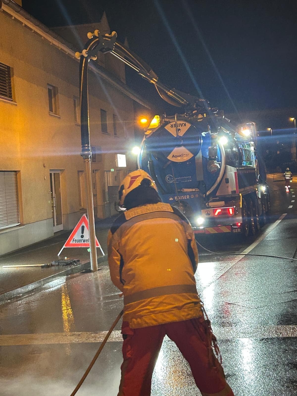 Saug- und Spülwagen der A-Z Kanalreinigung bei einem nächtlichen Einsatz mit der Feuerwehr
